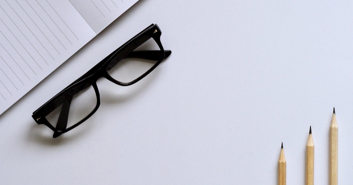 paper glasses and pencils on a flat lay white background