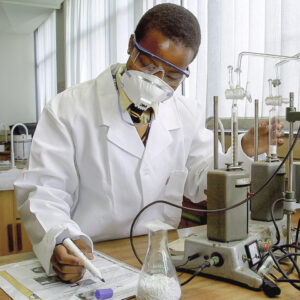 international student working in a lab wearing white smock and mouth cover